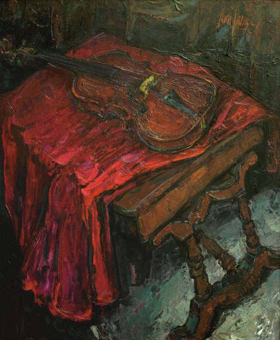 Un violín sobre una mesa de madera, con un mantel rojo que lo destaca.