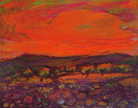 Atardecer vibrante con cielos anaranjados y tonalidades de rojo sobre un paisaje montañoso.