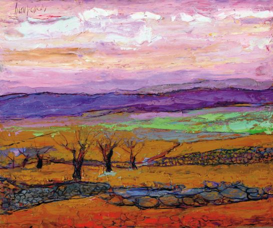 Paisaje con tonos cálidos, árboles sin hojas y montañas al fondo bajo un cielo colorido.